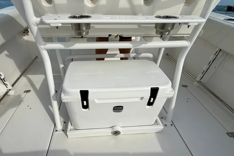 Slide: The Image of Edgewater 245CC 2023 boat interior with cooler and cup holders. - 29