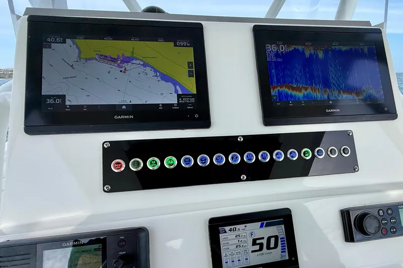 Slide: The Image of Edgewater 245CC 2023 boat dashboard with Garmin navigation and control panels. - 30