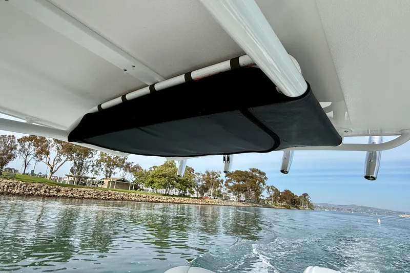 Slide: The Image of 2023 Edgewater 245CC boat with overhead storage, cruising on a scenic waterway. - 32