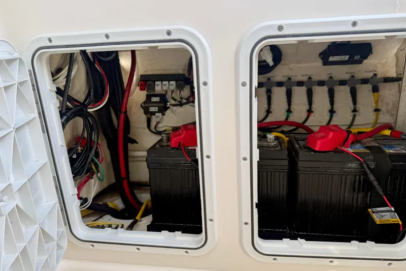 Slide: The Image of Electrical compartment of 2023 Edgewater 245CC boat, featuring batteries and wiring. - 33