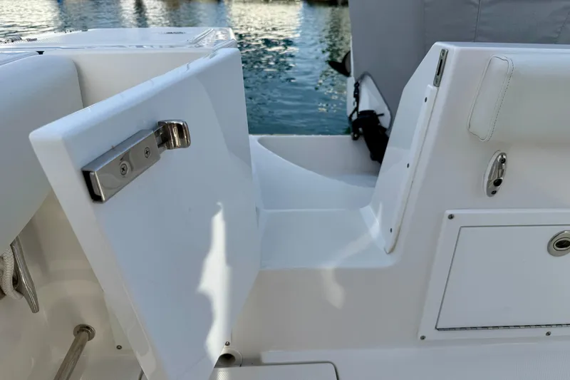 Slide: The Image of 2023 Edgewater 245CC boat interior with open storage compartment by the water. - 34