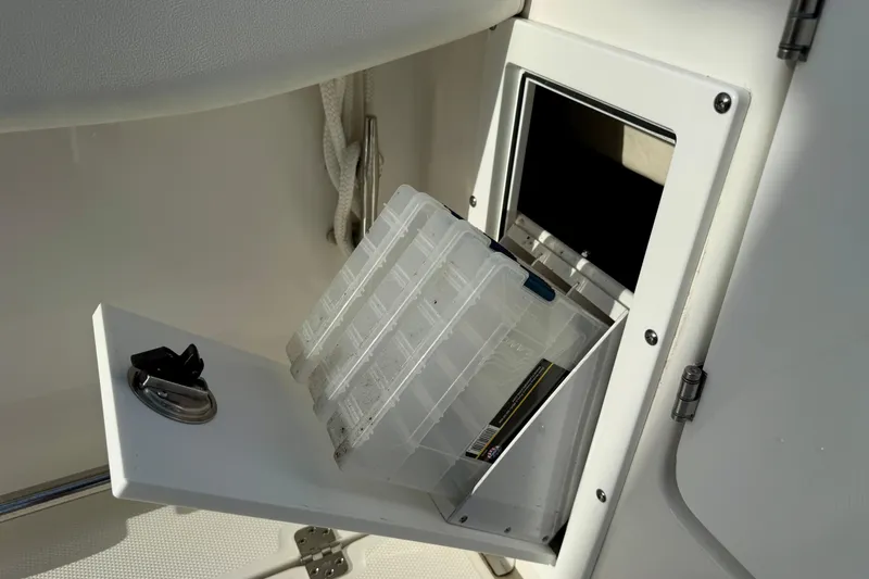 Slide: The Image of Storage compartment on 2023 Edgewater 245CC boat with tackle boxes. - 35