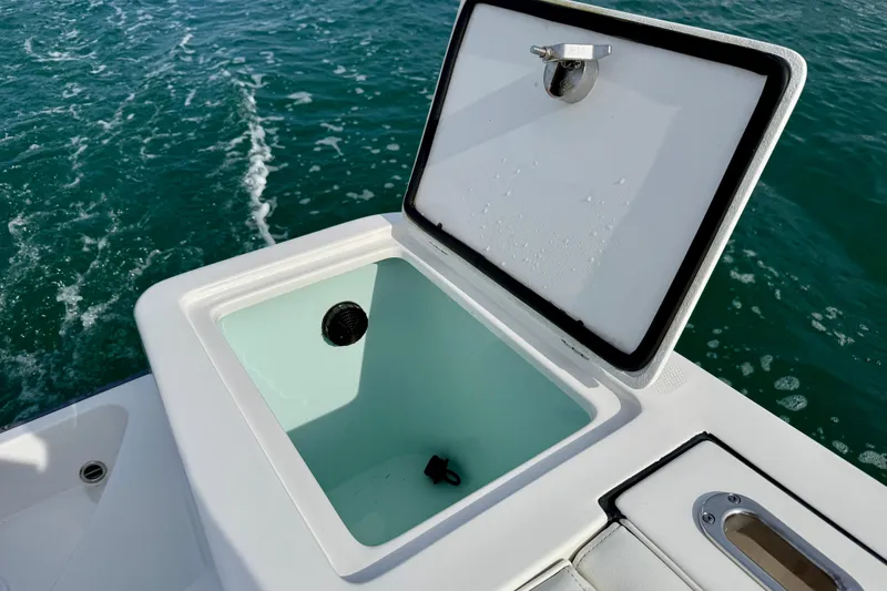 Slide: The Image of Open storage compartment on 2023 Edgewater 245CC boat, with ocean background. - 8
