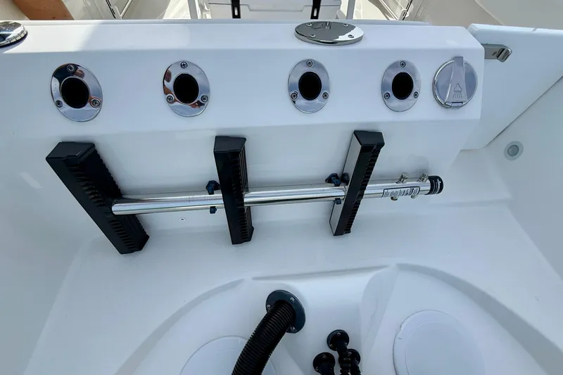 Slide: The Image of 2023 Edgewater 245CC boat deck with rod holders and utility features. - 9