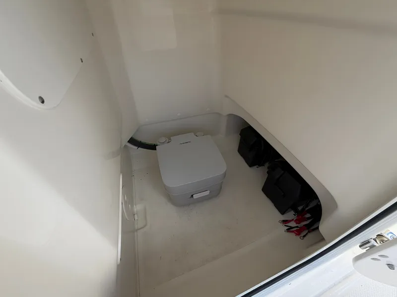 Slide: The Image of Interior of a Boston Whaler 210 Montauk with a portable toilet and battery compartment. - 24