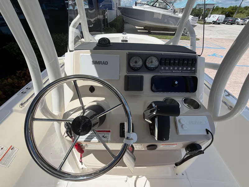Slide: The Image of The image shows the helm of a Boston Whaler 210 Montauk with a steering wheel and instruments. - 20
