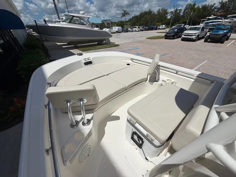 Slide: The Image of The image shows the deck of a Boston Whaler 210 Montauk with beige cushions and a cooler. - 32