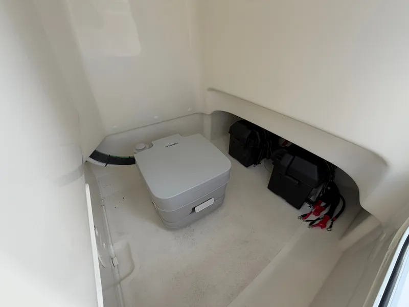 Slide: The Image of Interior of a Boston Whaler 210 Montauk with a portable toilet and batteries. - 25