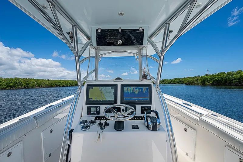 Slide: The Image of 2008 Buddy Davis 34 Center Console boat dashboard with navigation screens on a sunny day. - 4