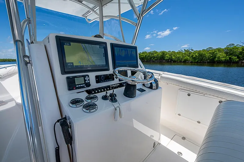 Slide: The Image of 2008 Buddy Davis 34 Center Console helm with navigation screens, steering wheel, and gauges. - 5