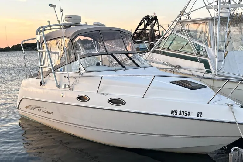 The Image of 2001 Stingray 240 CS boat docked at sunset, featuring sleek design and canopy. - 0