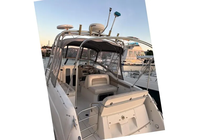 Slide: The Image of 2001 Stingray 240 CS boat with sleek design, docked at marina during sunset. - 1