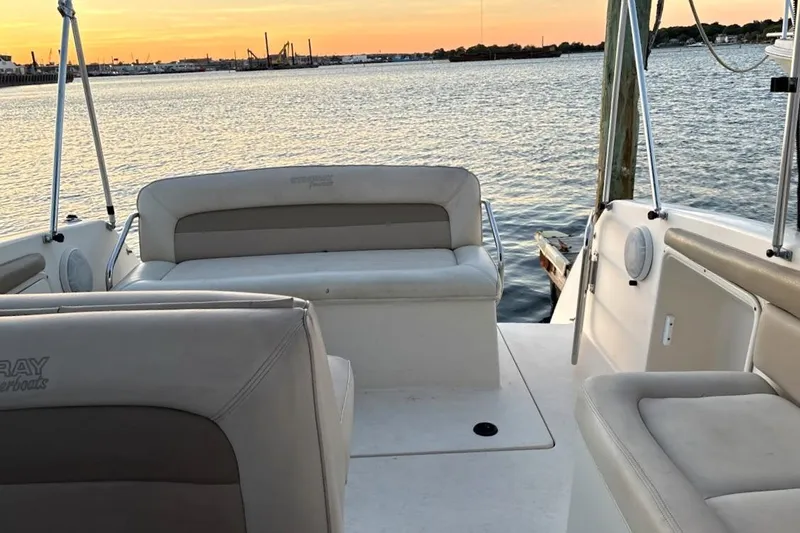Slide: The Image of 2001 Stingray 240 CS boat interior with seating, overlooking a serene sunset on the water. - 3