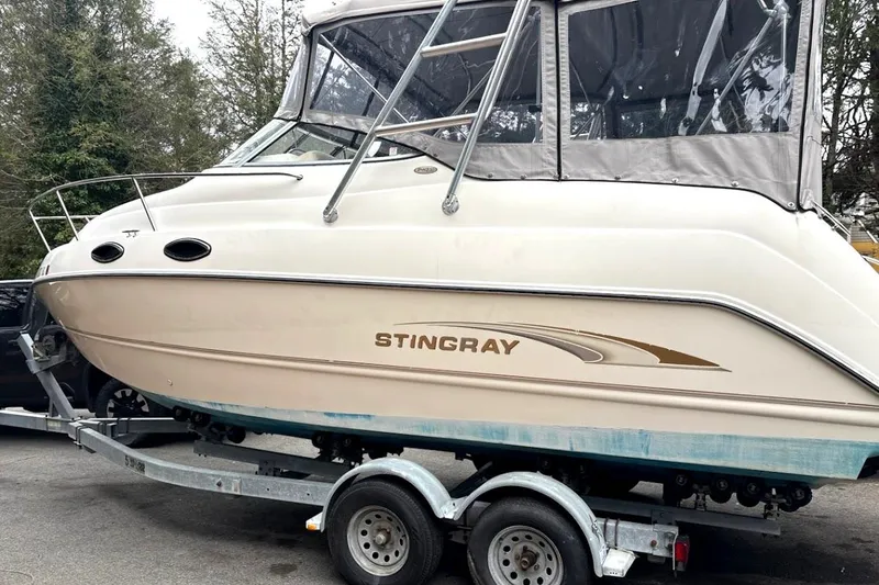 Slide: The Image of 2001 Stingray 240 CS boat on trailer, featuring sleek design and enclosed cabin. - 8