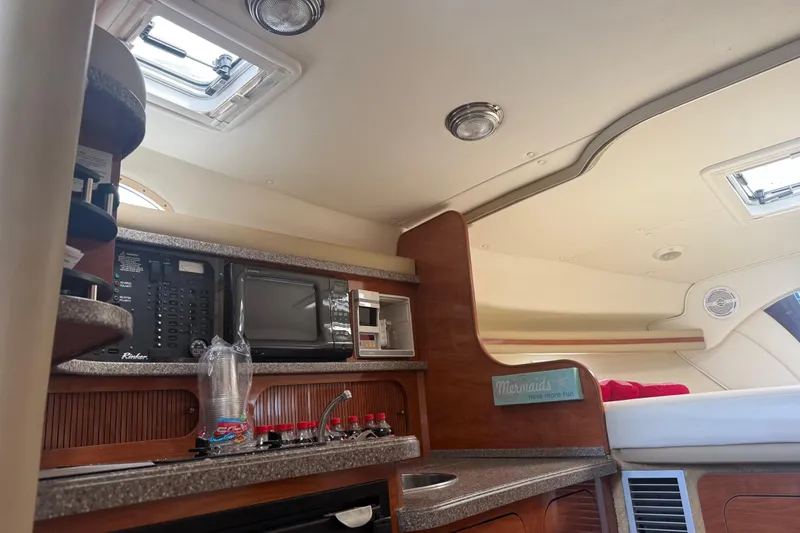 Slide: The Image of 2003 Rinker Fiesta Vee 342 cabin interior with kitchenette and cozy sleeping area. - 13