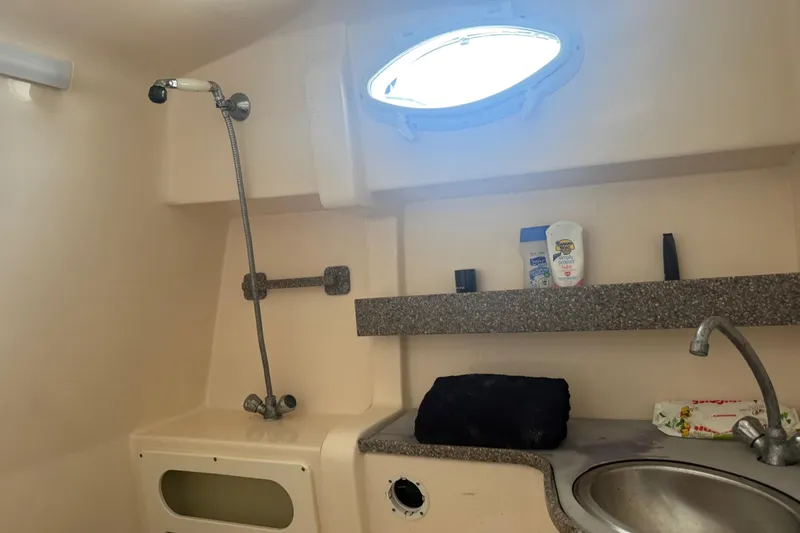 Slide: The Image of 2003 Rinker Fiesta Vee 342 bathroom with shower, sink, and toiletries on shelf. - 14