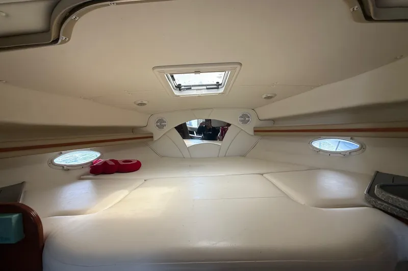 Slide: The Image of Interior cabin of 2003 Rinker Fiesta Vee 342 boat, featuring cozy seating and porthole windows. - 17
