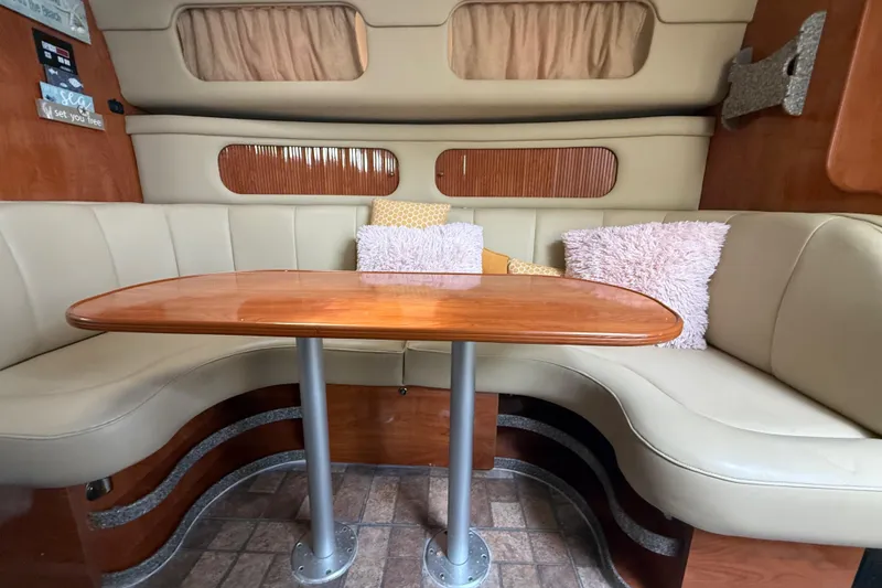 Slide: The Image of Interior of 2003 Rinker Fiesta Vee 342 with beige seating and wooden table. - 26