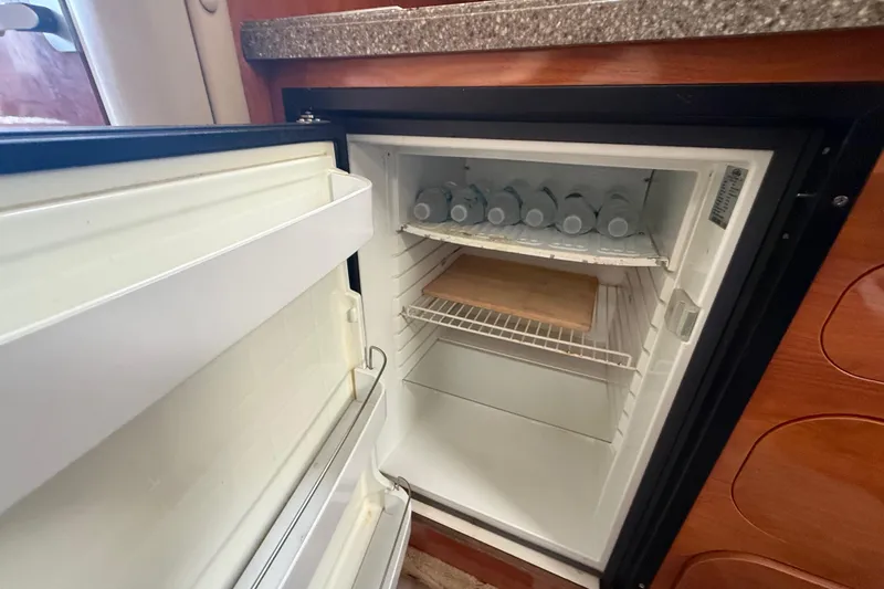 Slide: The Image of Open refrigerator inside 2003 Rinker Fiesta Vee 342 boat, stocked with water bottles. - 27