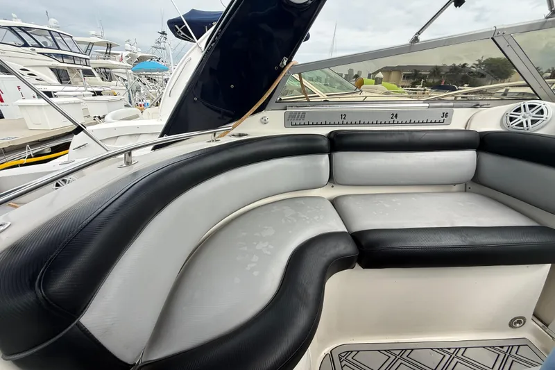 Slide: The Image of 2003 Rinker Fiesta Vee 342 boat interior with black and white seating at a marina. - 38