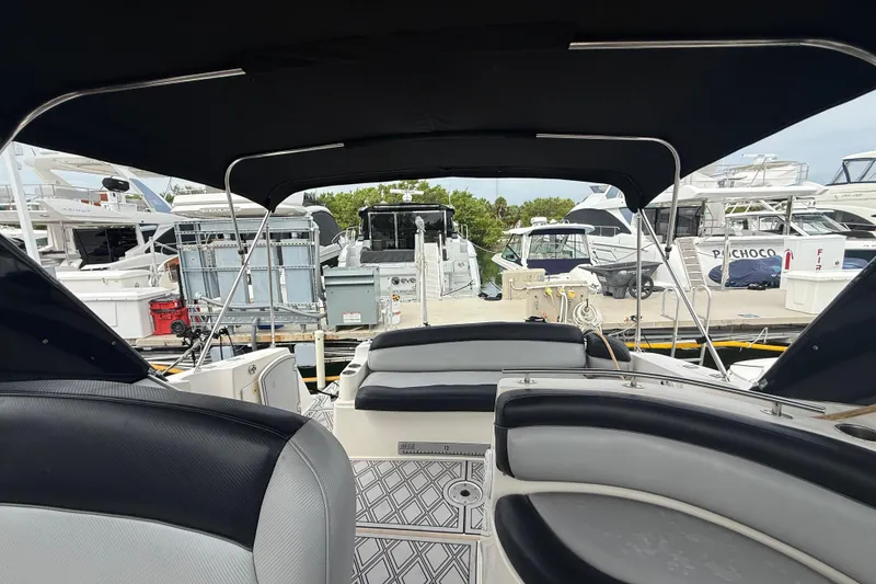 Slide: The Image of 2003 Rinker Fiesta Vee 342 boat interior at marina, featuring seating and canopy. - 4