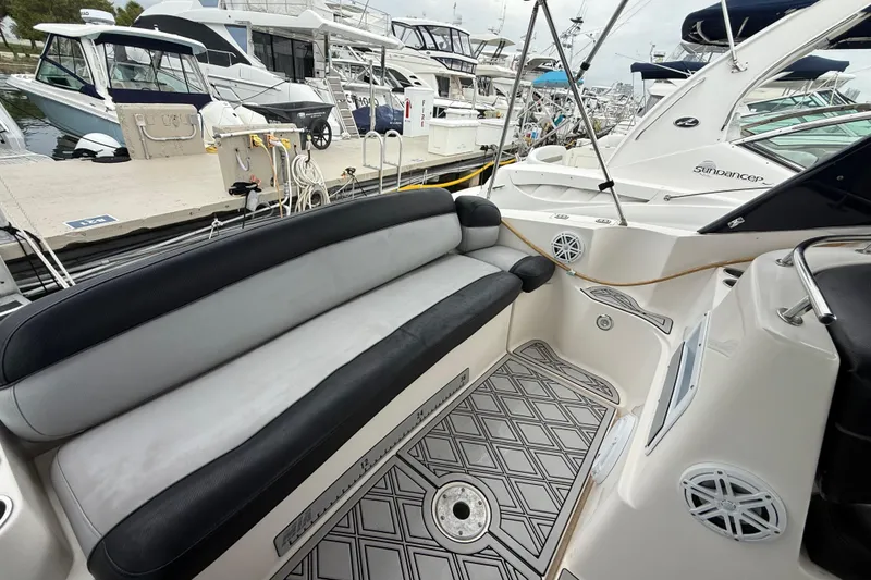 Slide: The Image of 2003 Rinker Fiesta Vee 342 boat interior with cushioned seating at a marina. - 40