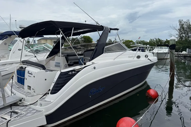 Slide: The Image of 2003 Rinker Fiesta Vee 342 boat docked, featuring sleek design and black canopy. - 41
