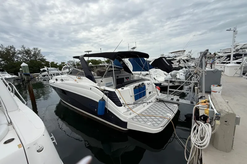 Slide: The Image of 2003 Rinker Fiesta Vee 342 docked at marina, overcast sky, surrounded by other boats. - 42