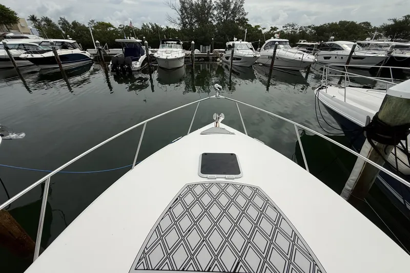 Slide: The Image of Bow view of 2003 Rinker Fiesta Vee 342 docked among other boats in a marina. - 44