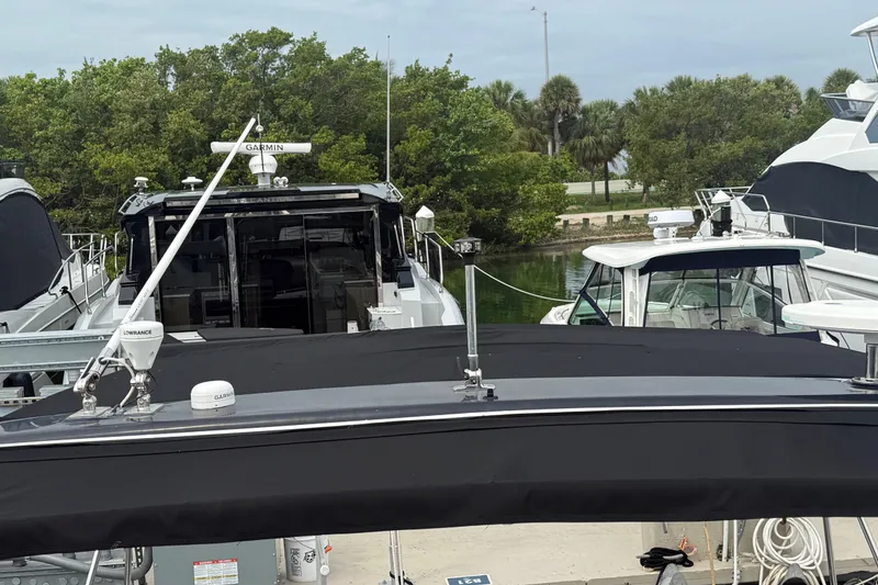 Slide: The Image of 2003 Rinker Fiesta Vee 342 docked among other boats, surrounded by lush greenery. - 45