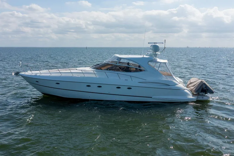 Slide: The Image of Luxury 2002 Cruisers 5370 yacht on open water under a partly cloudy sky. - 3
