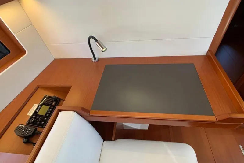 Slide: The Image of Interior of 2020 Beneteau Oceanis 46.1 yacht with navigation station and sleek wood finish. - 23
