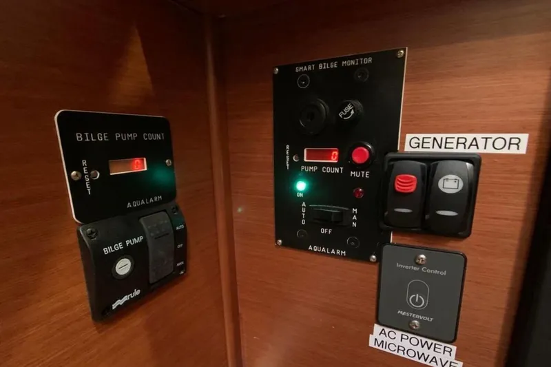 Slide: The Image of Control panel of a 2020 Beneteau Oceanis 46.1 yacht, featuring bilge pump and generator switches. - 29
