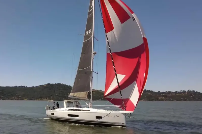 Slide: The Image of 2020 Beneteau Oceanis 46.1 sailing with vibrant red and white spinnaker on a sunny day. - 3