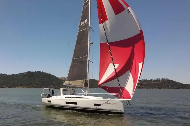Slide: The Image of 2020 Beneteau Oceanis 46.1 sailing with vibrant red and white spinnaker on a calm lake. - 33