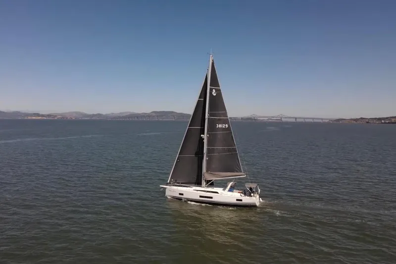 Slide: The Image of 2020 Beneteau Oceanis 46.1 sailing on open water with distant bridge view. - 34