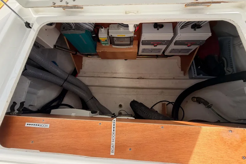 Slide: The Image of Storage compartment of a 2020 Beneteau Oceanis 46.1 sailboat, featuring electrical components and hoses. - 41