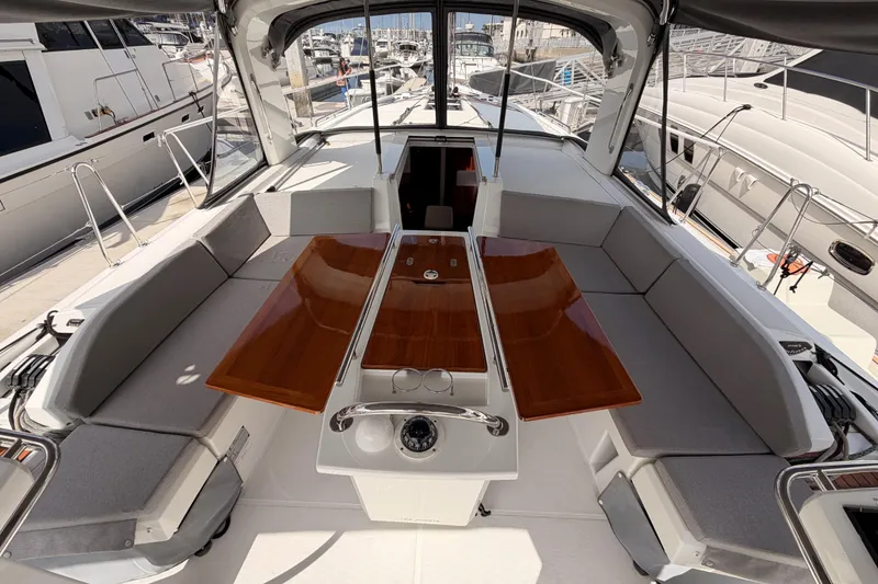 Slide: The Image of 2020 Beneteau Oceanis 46.1 yacht cockpit with seating and wooden table. - 55