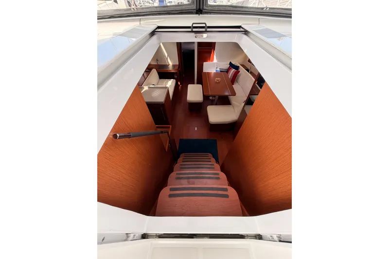 Slide: The Image of Interior view of 2020 Beneteau Oceanis 46.1 yacht, featuring elegant wooden stairs and cozy seating area. - 58