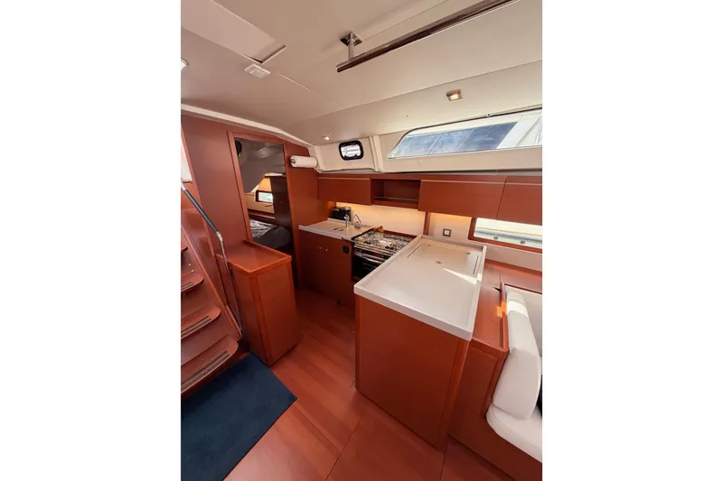 Slide: The Image of Interior of 2020 Beneteau Oceanis 46.1 yacht, featuring modern kitchen and wooden cabinetry. - 62