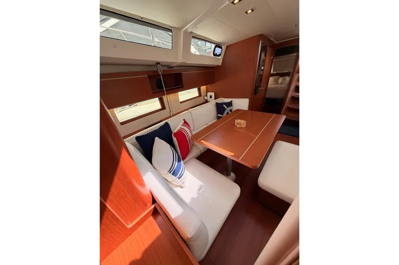 Slide: The Image of Interior of 2020 Beneteau Oceanis 46.1 yacht with cozy seating and wooden table. - 98