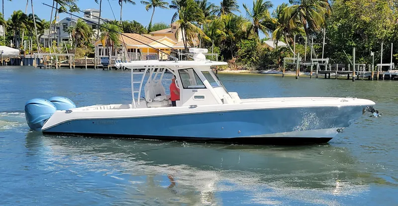 The Image of 2024 Everglades 365 Center Console boat cruising on a tropical waterway. - 0