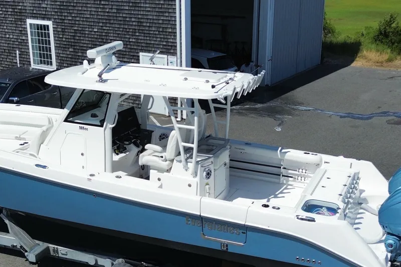 Slide: The Image of 2024 Everglades 365 Center Console boat with sleek design, parked near a building. - 2