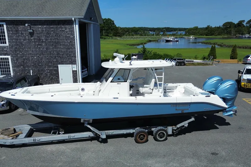 Slide: The Image of 2024 Everglades 365 Center Console boat on trailer, parked near a scenic waterfront. - 28