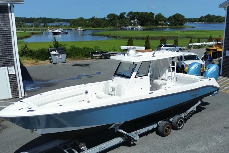 Slide: The Image of 2024 Everglades 365 Center Console boat on trailer near waterfront. - 1