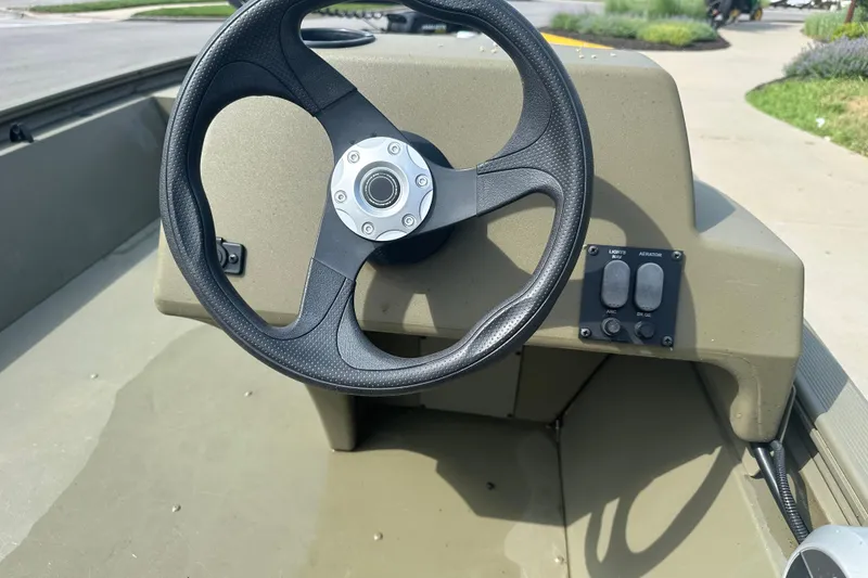 Slide: The Image of Steering wheel of 2024 Tracker Grizzly 1648 SC boat, featuring control panel. - 17