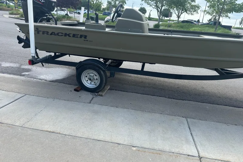 Slide: The Image of 2024 Tracker Grizzly 1648 SC boat on trailer, parked on a street. - 23