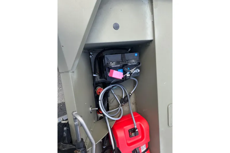 Slide: The Image of 2024 Tracker Grizzly 1648 SC boat interior showing battery and fuel tank setup. - 25