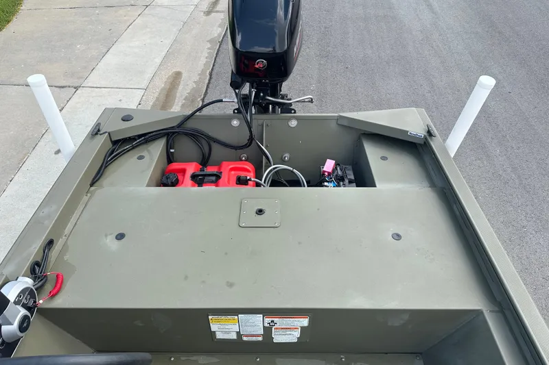 Slide: The Image of 2024 Tracker Grizzly 1648 SC boat with motor and equipment on a paved surface. - 27