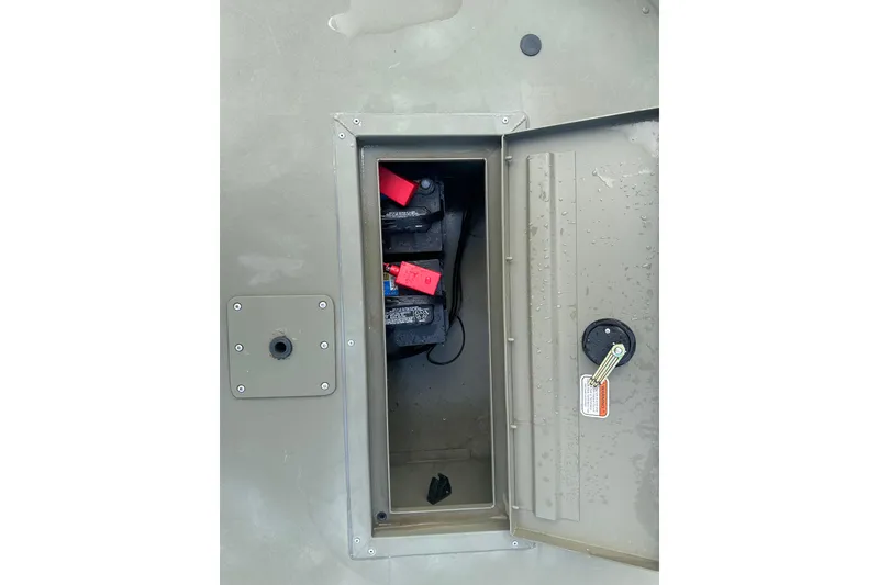 Slide: The Image of 2024 Tracker Grizzly 1648 SC boat battery compartment with open hatch and visible wiring. - 28